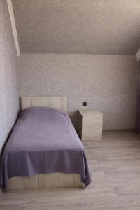 1 dormitorio con 1 cama con manta morada en Sweet Home en Yengidzha