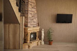 a fireplace in a living room with a statue next to it at Sweet Home in Yengidzha