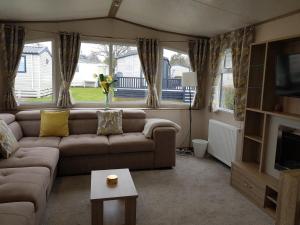 a living room with a couch and a tv at 2 Bedroom Lodge, Milford on Sea in Milford on Sea