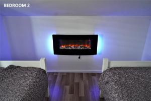 a living room with a tv and a fireplace on the wall at ARIA DELUXE Mobile Homes with Terme Čatež Tickets in Čatež ob Savi