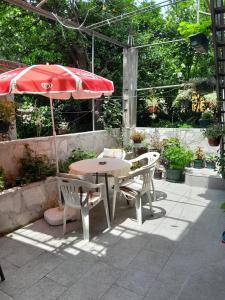 een tafel en stoelen en een parasol op een patio bij Apartment Radovic in Kotor