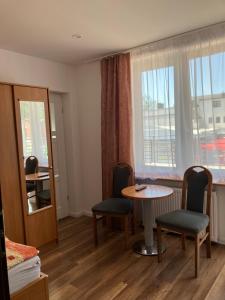 ein Raum mit einem Tisch und Stühlen und einem Fenster in der Unterkunft AGAT Pokoje Gościnne Apartamenty in Pobierowo