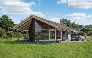 une maison avec un toit en pente sur une pelouse dans l'établissement Gorgeous Home In Sams With Kitchen, à Onsbjerg