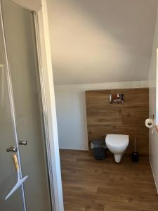 ein Badezimmer mit einer weißen Toilette in einem Zimmer in der Unterkunft AGAT Pokoje Gościnne Apartamenty in Pobierowo