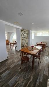 a dining room with wooden tables and chairs at Pensiunea Tesoro in Corbeni