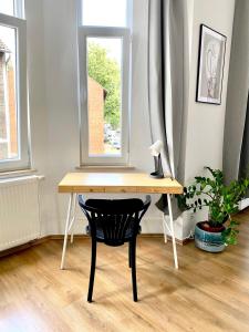 einen Schreibtisch mit einem Stuhl vor einem Fenster in der Unterkunft 2 Rooms, free Parking, 25 min to Düsseldorf, 150 Mbps WLAN in Duisburg