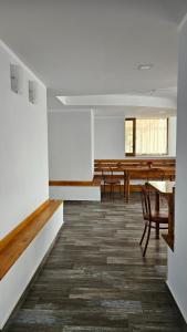 an empty room with tables and chairs and a dining room at Pensiunea Tesoro in Corbeni