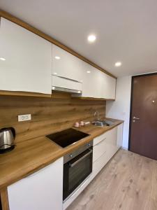 una cocina con armarios blancos y fregadero en The Amazing Loft en Liubliana