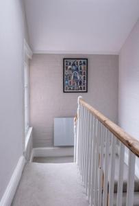 溫徹斯特的住宿－Beautiful & Spacious Retreat in Winchester，走廊上设有楼梯,墙上挂有绘画作品