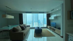 a living room with a couch and a large window at The H Tower Rasuna Suites Kuningan jakarta by Villaloka in Jakarta