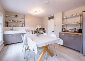 a kitchen with a white table and white chairs at Beautiful & Spacious Retreat in Winchester in Winchester