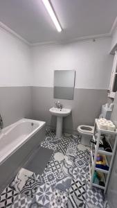 a bathroom with a tub and a sink and a toilet at SÓLO HABITACIÓN GRANDE CON BALCOn in Lisbon