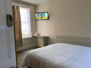 a bedroom with a bed and a television on the wall at Sylvern House in Scarborough