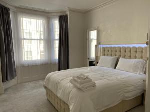 a bedroom with a large white bed with towels on it at Sylvern House in Scarborough