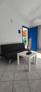 a living room with a black couch and a white table at Villa Rodanthi Sivota in Syvota