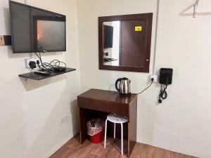 a room with a desk with a television and a stool at Hotel Citra in Brinchang +30 photos