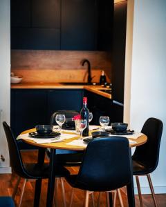 einen Tisch mit Stühlen, eine Flasche Wein und Gläser in der Unterkunft LAGATOR LUX in Loznica