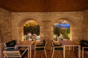 un restaurante con mesas y sillas en una pared de piedra en Artelier Vama Veche, en Vama Veche