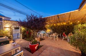 a patio with tables and chairs in a garden at night at Artelier Vama Veche in Vama Veche