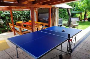 a blue ping pong table on a patio at Belloapartamento Ház Balatonkenese, Strand 800m, Jakuzzi in Balatonkenese