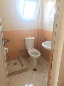 a bathroom with a toilet and a sink at TAFA A. in Fier