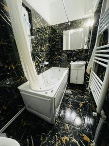 ママイア・ノルドにあるVila Cris Apartmentsの黒と金のバスルーム(バスタブ、シンク付)