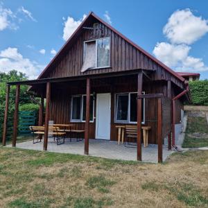 a large wooden house with a patio and a table at Griežto 5 in Zarasai