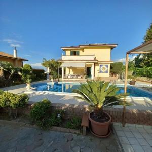 uma villa com piscina em frente a uma casa em Villa Solemar em Briatico