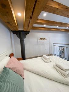 1 cama blanca grande con 2 toallas encima en The Amazing Loft en Liubliana
