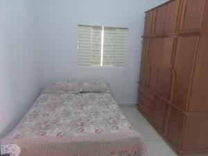 a small bedroom with a bed and a dresser at Recanto Sossego in Pirenópolis