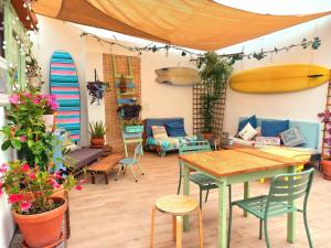 a patio with a table and chairs and surfboards at Ethic Surf House in Ferrel