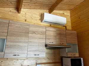 una cocina con paredes de madera y una luz en el techo en Domki Me Mazury en Giżycko