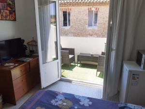 a bedroom with a door open to a patio at Serge le belge sejour chez l habitant in Lézignan-Corbières