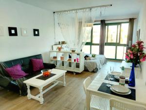 een woonkamer met een bank en een tafel bij Estudios Center in Corralejo