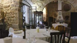 ein Restaurant mit weißen Tischen und Stühlen in einem Gebäude in der Unterkunft Fattoria Manostalla Villa Chiarelli in Balestrate + 50 Fotos