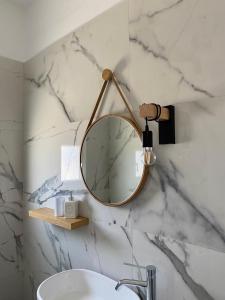 La salle de bains est pourvue d'un miroir et d'un lavabo. dans l'établissement Fikas Hotel, à Naxos Chora