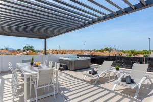 un patio avec une table et des chaises ainsi qu'un barbecue sur le toit. dans l'établissement Villa Adela, à San Javier