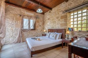a bedroom with a bed in a stone wall at The Stonemade Houses in Falasarna