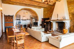 a living room with white furniture and a fireplace at Le 7 Camicie in Castelnuovo dellʼAbate