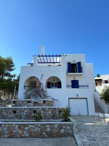 a white house with a stone wall at Molly’s Home in Víssa