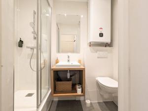 La salle de bains est pourvue de toilettes, d'un lavabo et d'une douche. dans l'établissement Le DODO Part-Dieu, à Lyon