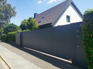 uma cerca preta em frente a uma casa em Modernes, Mini-Apartment Nürnberg,Playmobil em Zirndorf