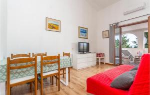 ein Wohnzimmer mit einem Tisch und einem roten Sofa in der Unterkunft Stunning Apartment In Pinezici With 2 Bedrooms And Wifi in Pinezici