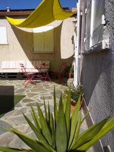 une terrasse avec un parasol jaune, une table et des chaises dans l'établissement Casa Davia. Studio indépendant meublé., à Furiani