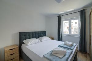 a bedroom with a large bed and a window at FRANKO in Senj