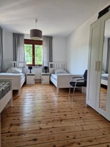 a bedroom with two beds and a wooden floor at Lindenwohnung an historischer Mühle in Holzhausen