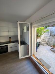 a kitchen with a large sliding glass door at La Flibuste des Goudes, maison avec jardins aménagés vue et proche mer au coeur du Parc National du Massif des Calanques in Marseille