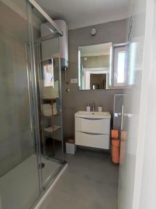 een badkamer met een wastafel en een glazen douche bij Kaleta in Supetar