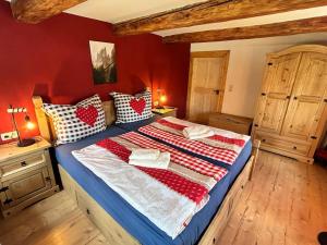 a bedroom with a large bed with red walls at Ferienhaus Hexe mit Whirlpool, Sauna, Garten in Großschönau