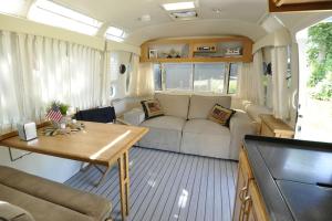 sala de estar con sofá y mesa en Airstream Retro USA caravan en Earnewâld